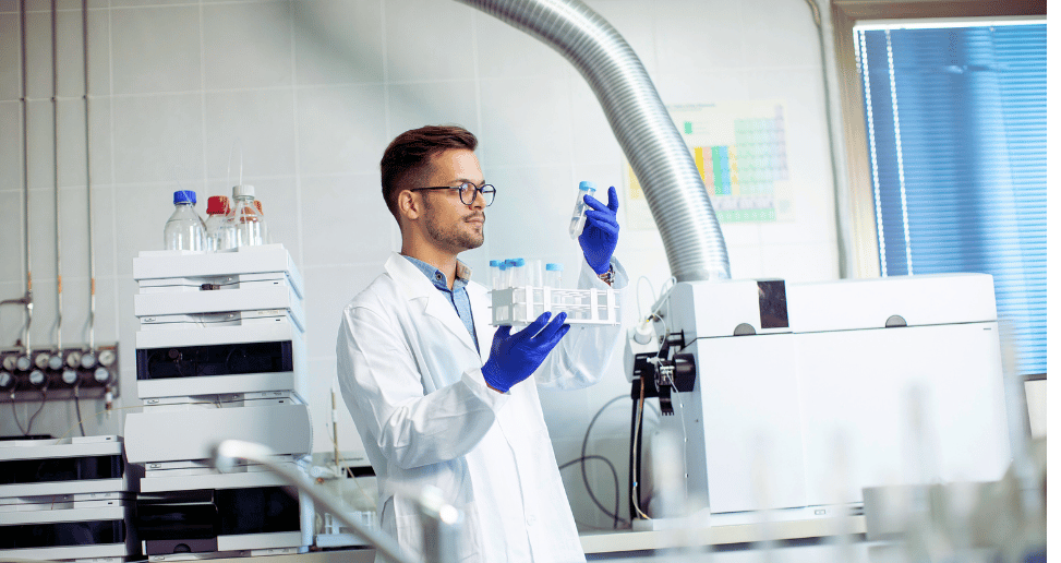 Young researcher workin with chemical samples in laboratory with HPLC system and chromatography equipment.