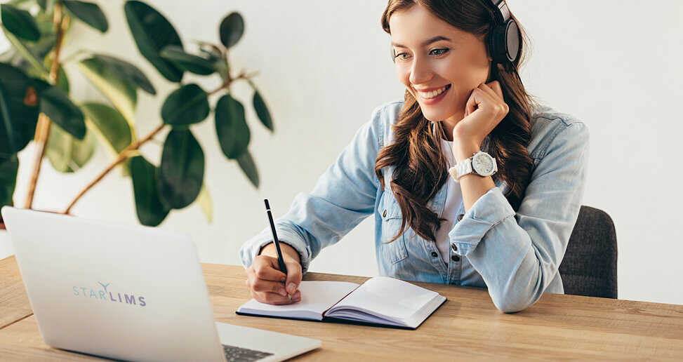 The woman looking at the computer monitor and taking notes