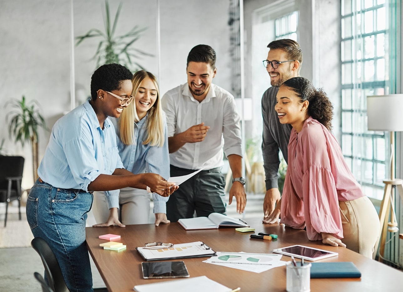 STARLIMS Coworkers expressing teamwork and success during a meeting in the office.