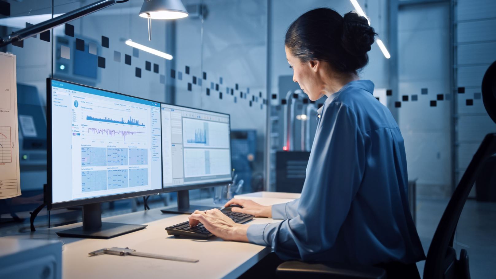 Woman lab worker reviews STARLIMS Advanced Analytics on a computer in the Laboratory