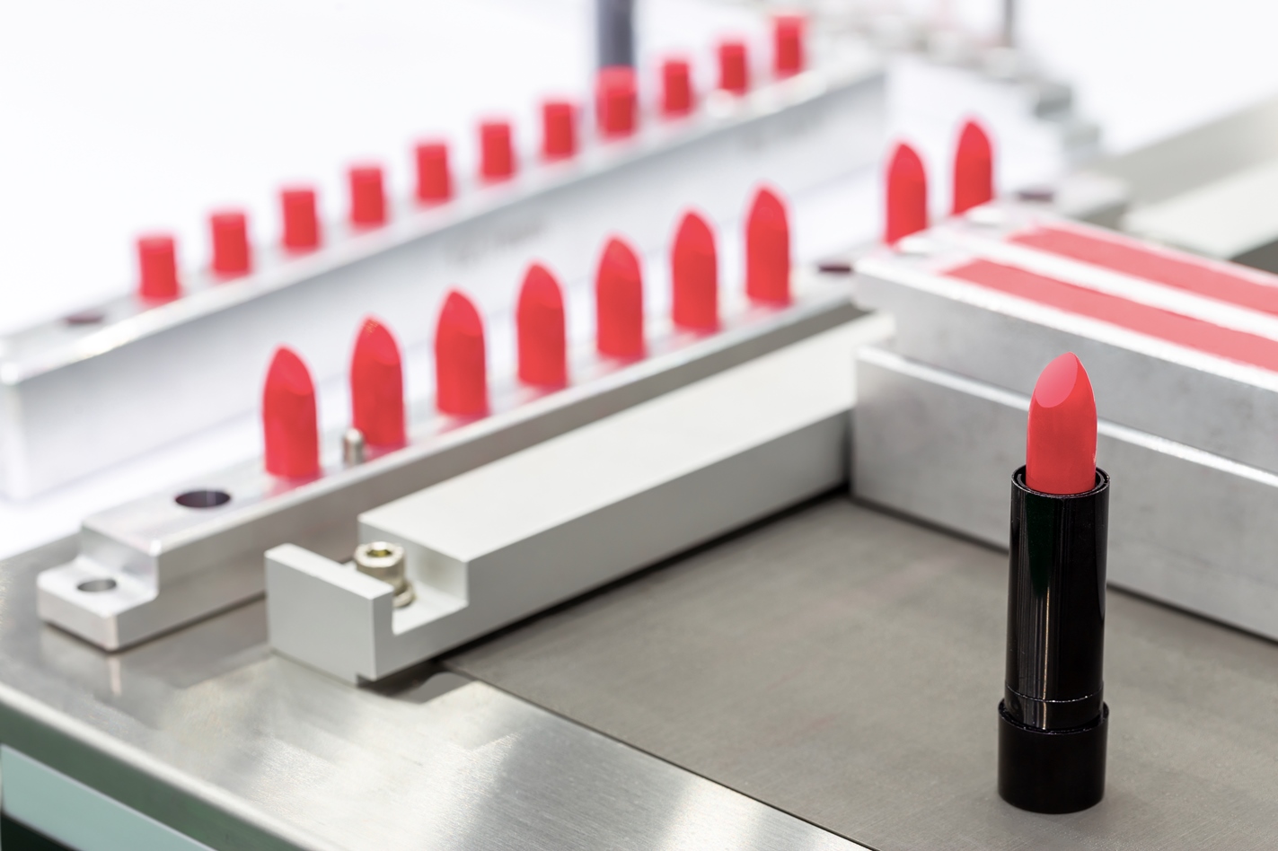 A lipstick vial filling machine optimized with consumer goods LIMS, ELN, LES, and SDMS software in a cosmetics factory.