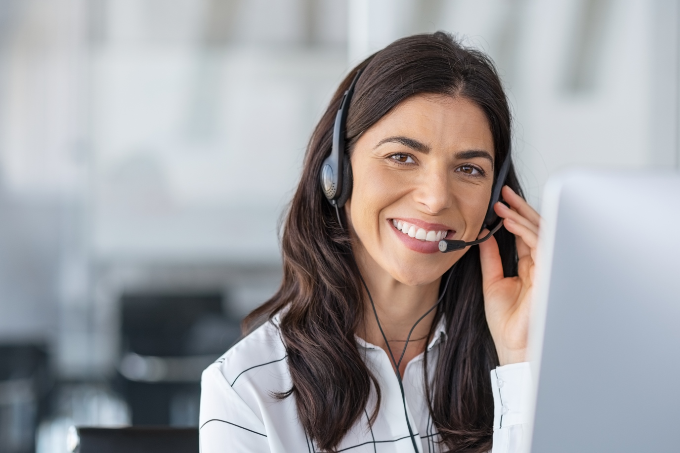 Call center agent with headset working on support hotline in modern office.