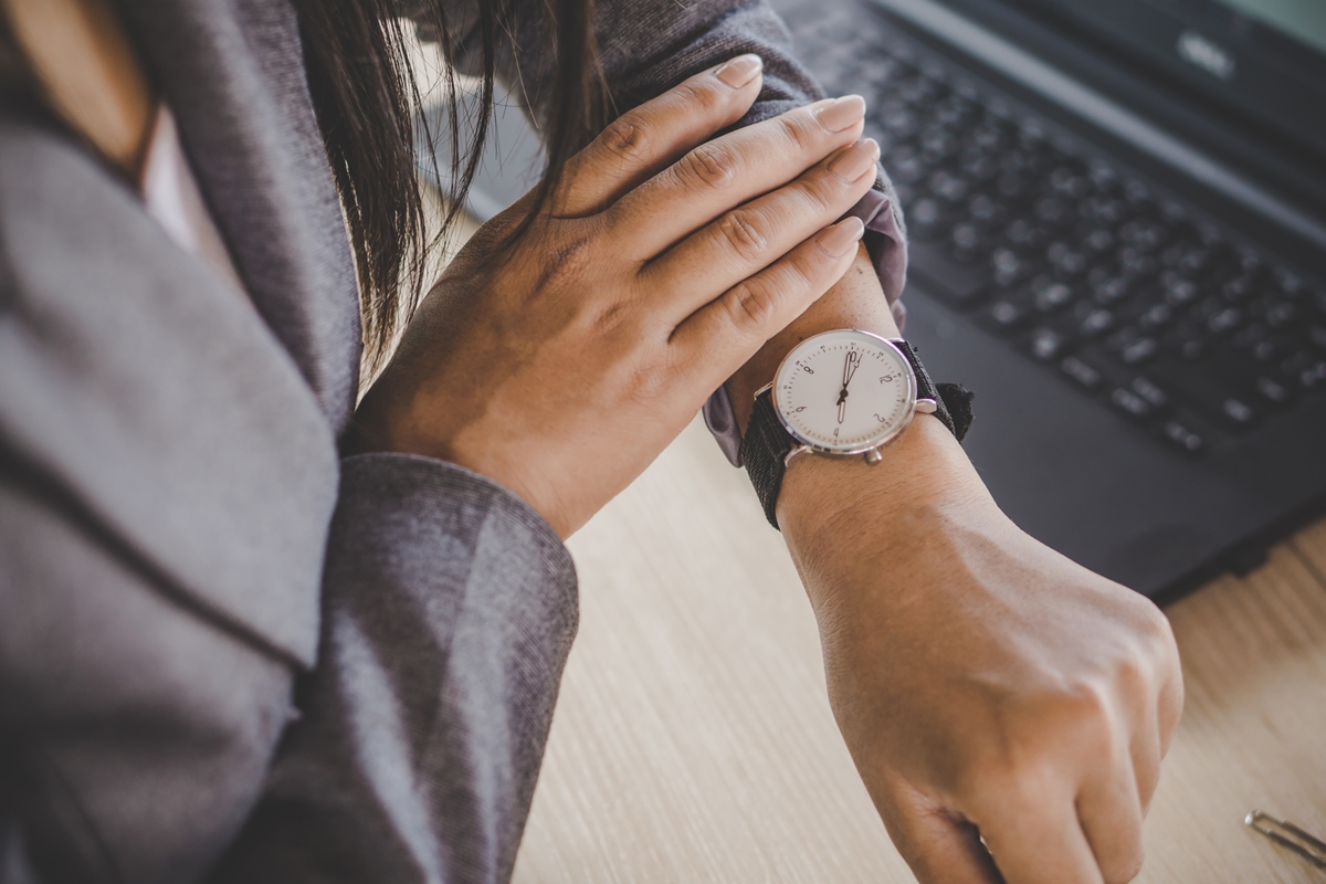 Businesswoman checking the time on watch