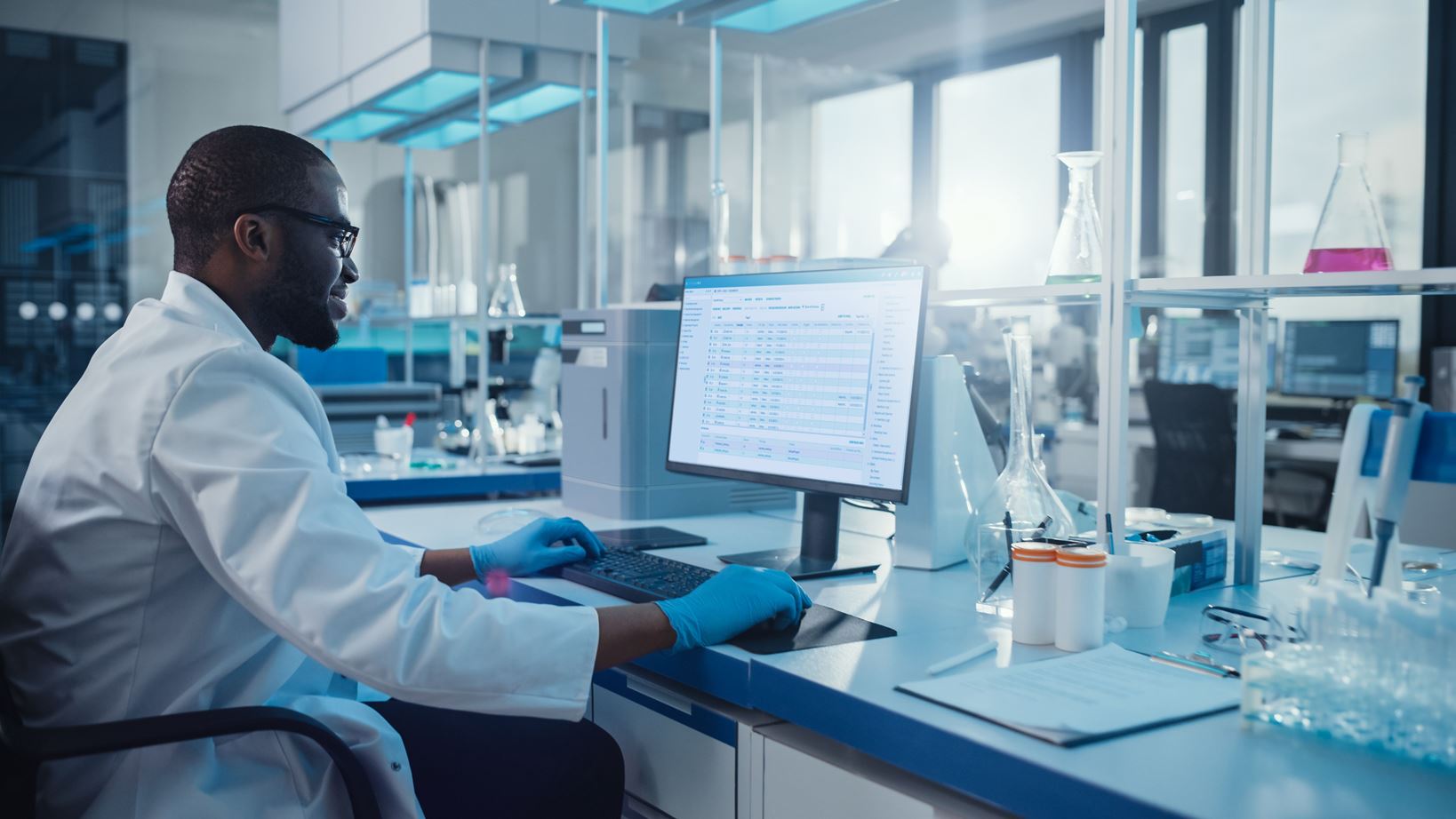 Laboratory worker works on a computer system with the STARLIMS scientific data management system (SDMS).