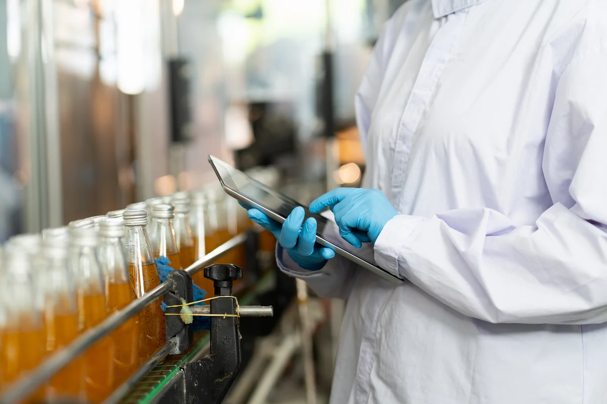 Laboratory technician checking the bottles on the production line