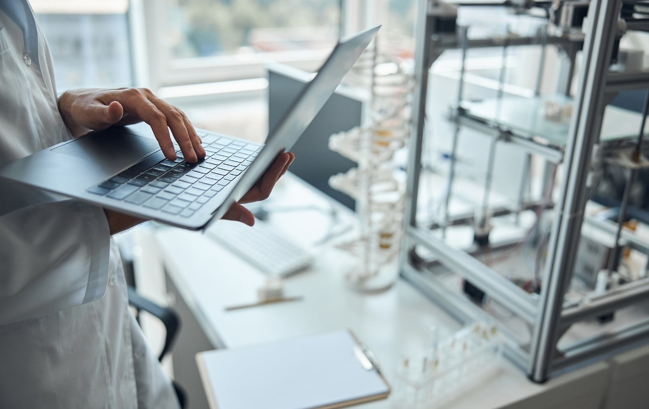 Hands holding a laptop and working.