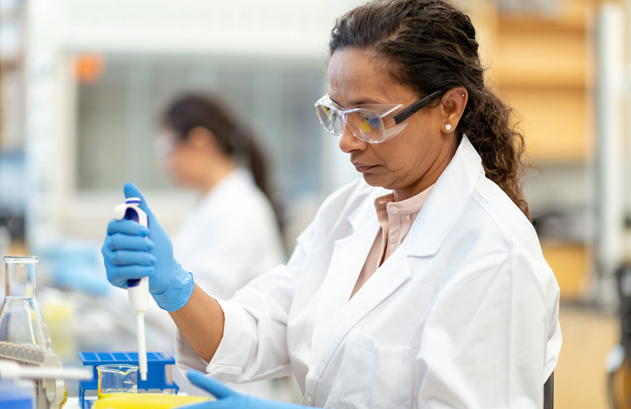 Scientist using a pipette in a laboratory.